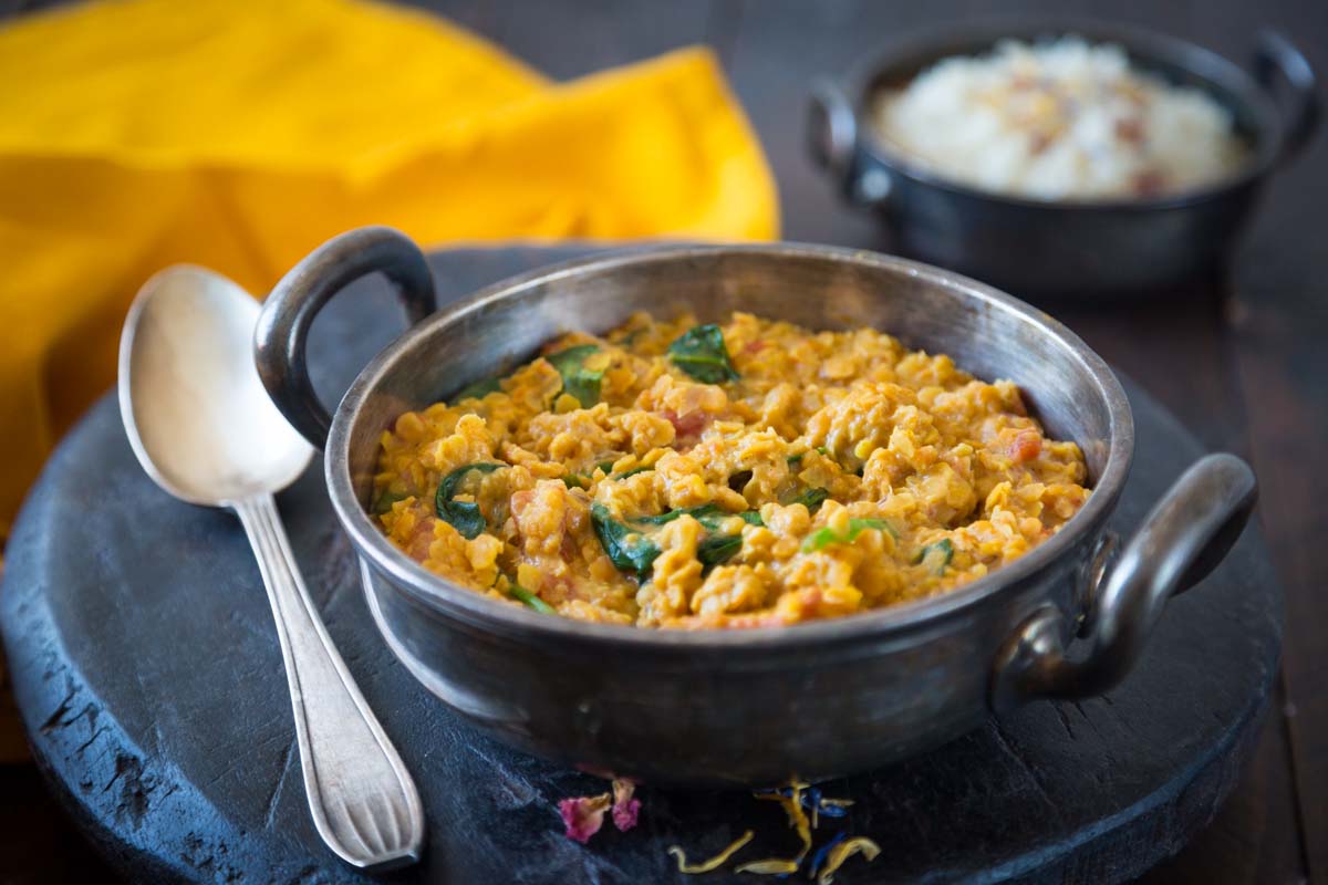 Bol de dahl de lentilles corail au lait de coco garni de coriandre fraîche, servi avec du riz